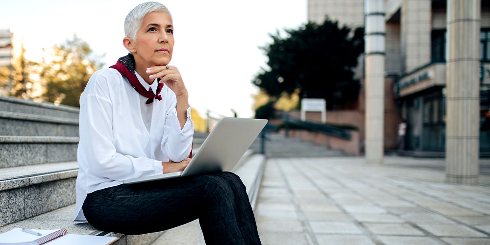 Woman Sitting With Laptop | Aluma Capital (Pty) Ltd